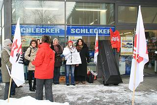 Frauen protestieren vor Schlecker-Filiale mit Gewerkschaftsfahnen.